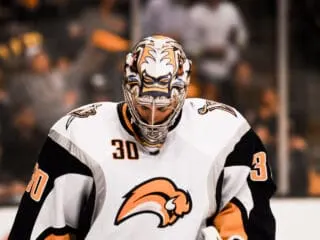 A hockey goaltender is standing on the ice, NHL player Ryan Miller.