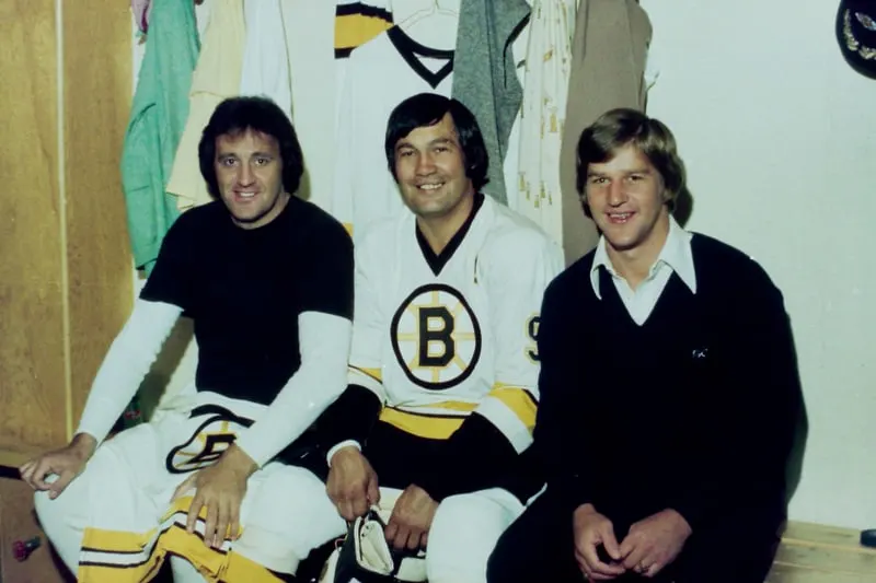 Three men in a locker posing for a photo during Bobby Orr's rise.