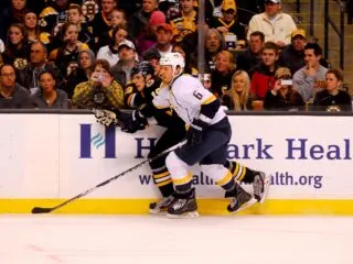 Two Montreal Canadiens players fighting for the puck in front of a crowd.