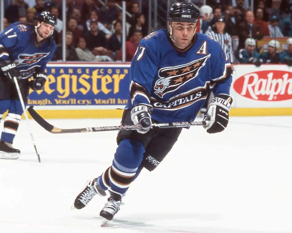A hockey player in a blue Washington Capitals uniform skates on the ice during a game, reminding fans of past intense matchups with the Boston Bruins.